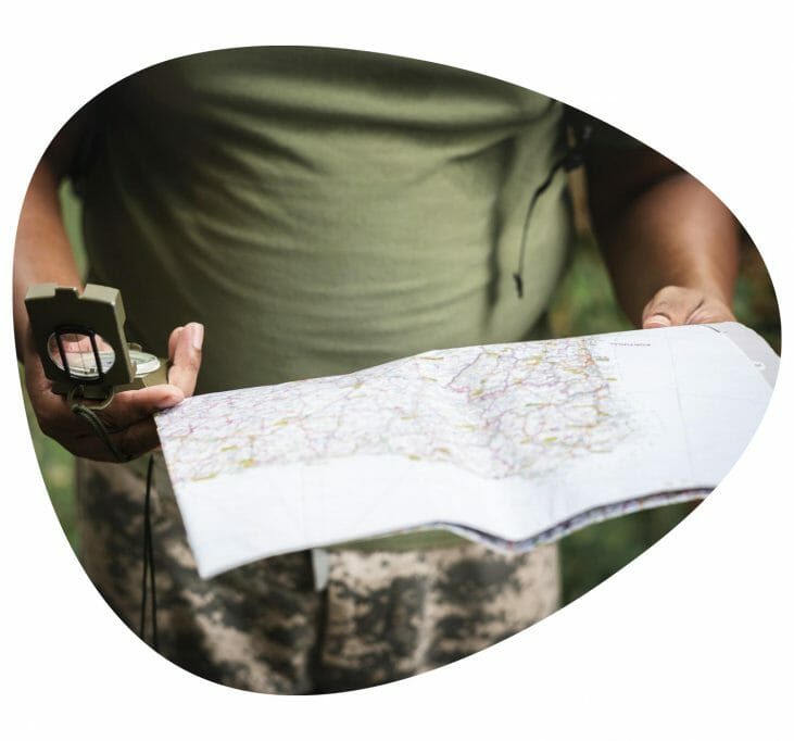 close-up of someone holding a map and compass